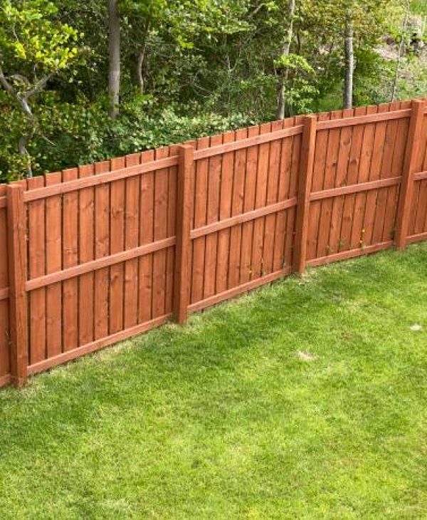 Wooden garden fence coated with medium oak colour paint UK